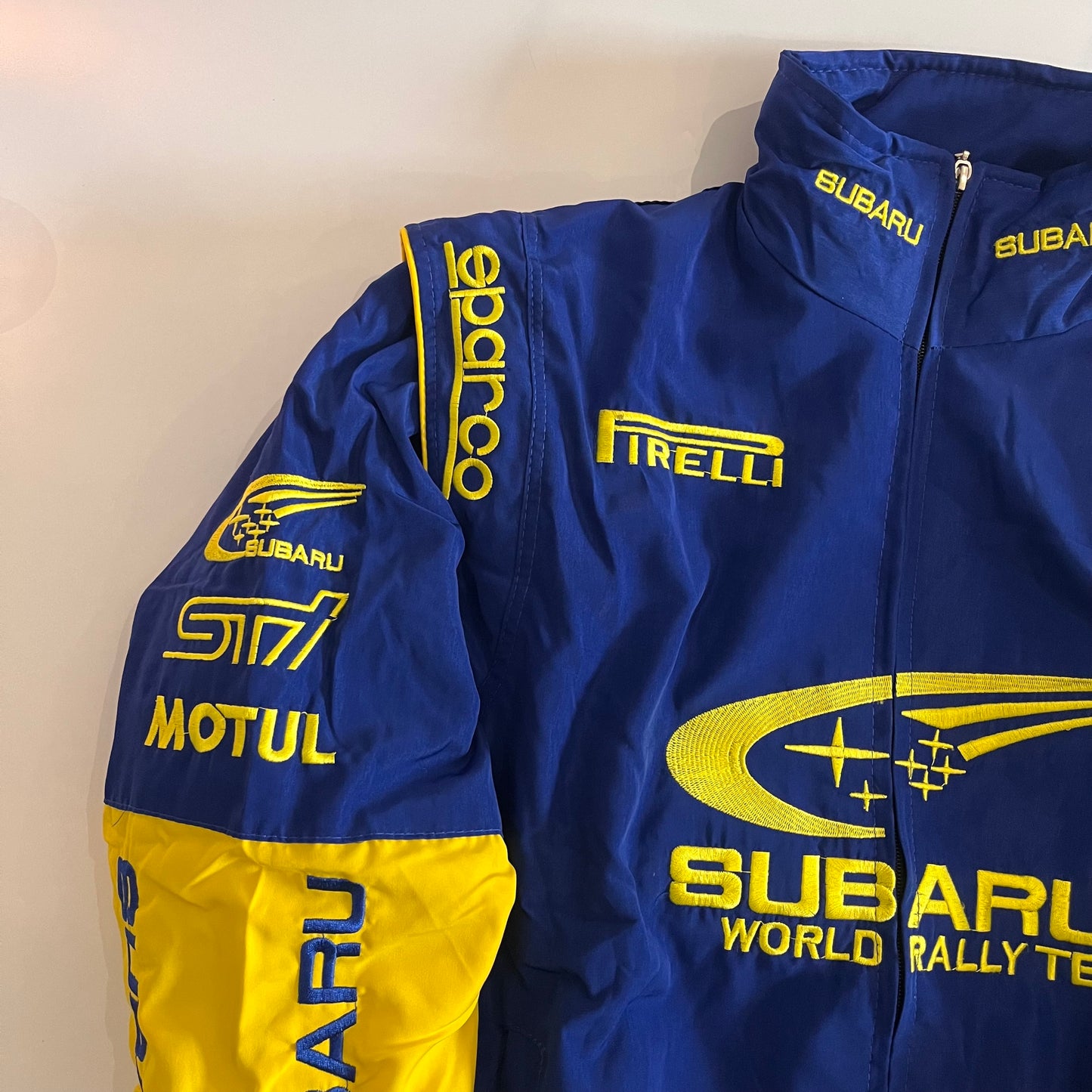 Subaru blue and yellow featuring embroidered sponsor logos